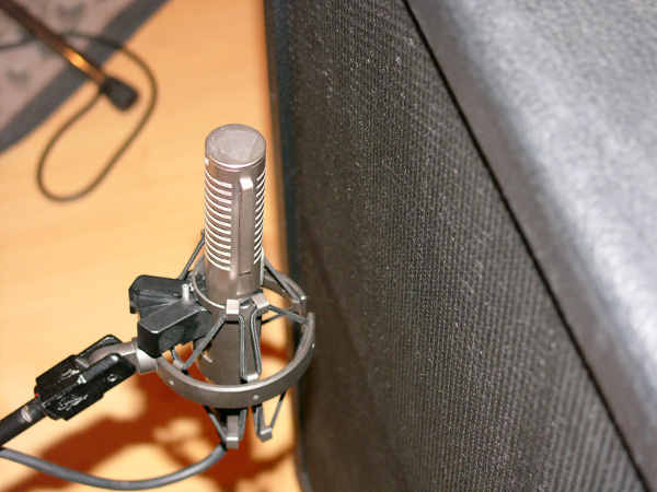 This shows a ribbon microphone positioned to record a guitar amplifier.